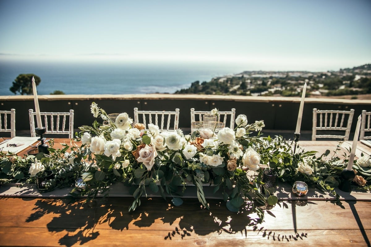 Reception table centerpiece with view of ocean behind it