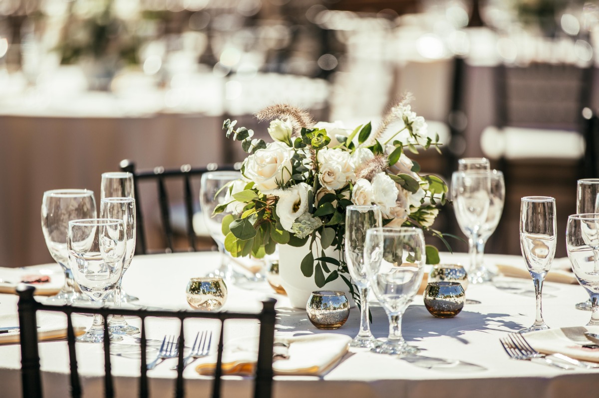 Reception table centerpiece with white flowers and greenery