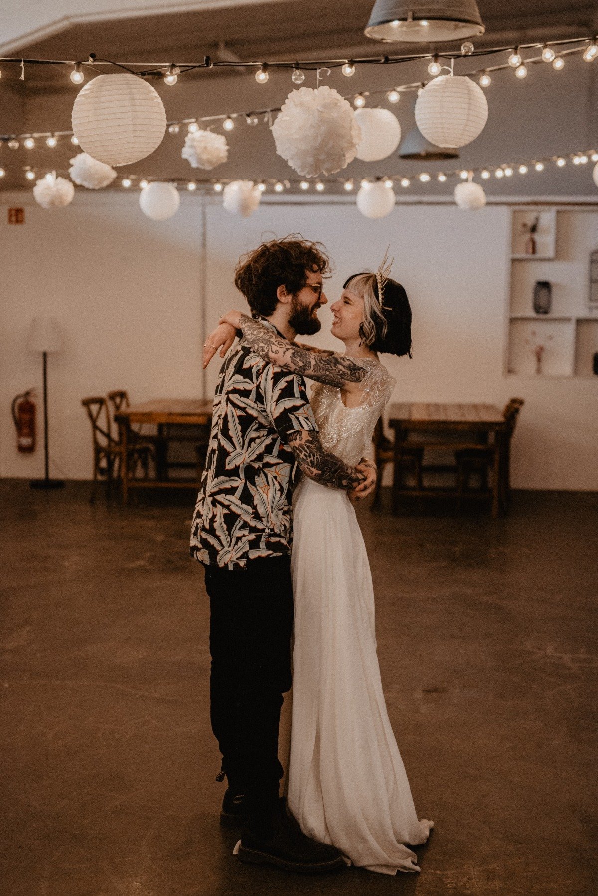 Bride and groom dancing under globe and string lights