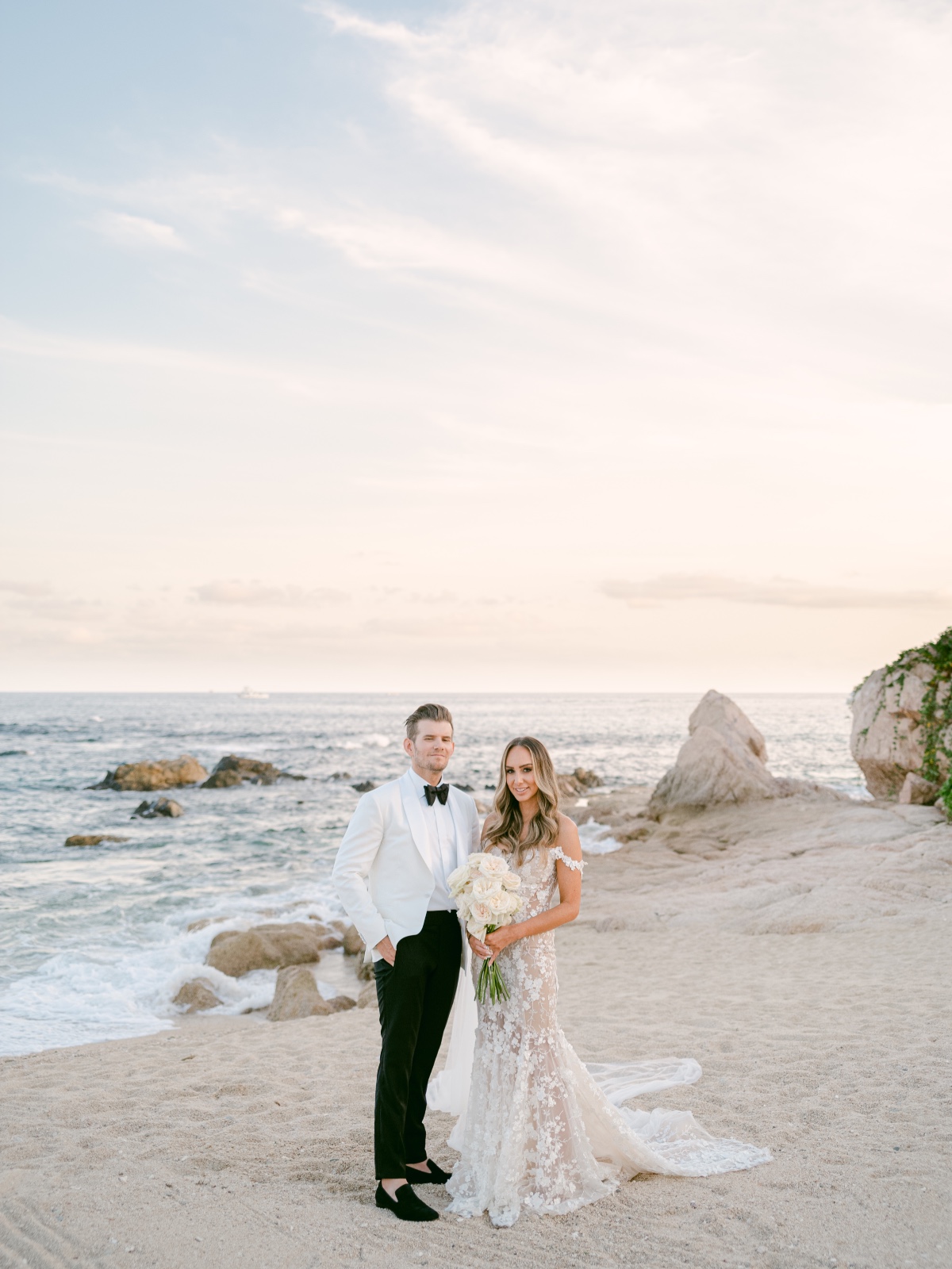Portrait of bride and groom on beach in front of ocean