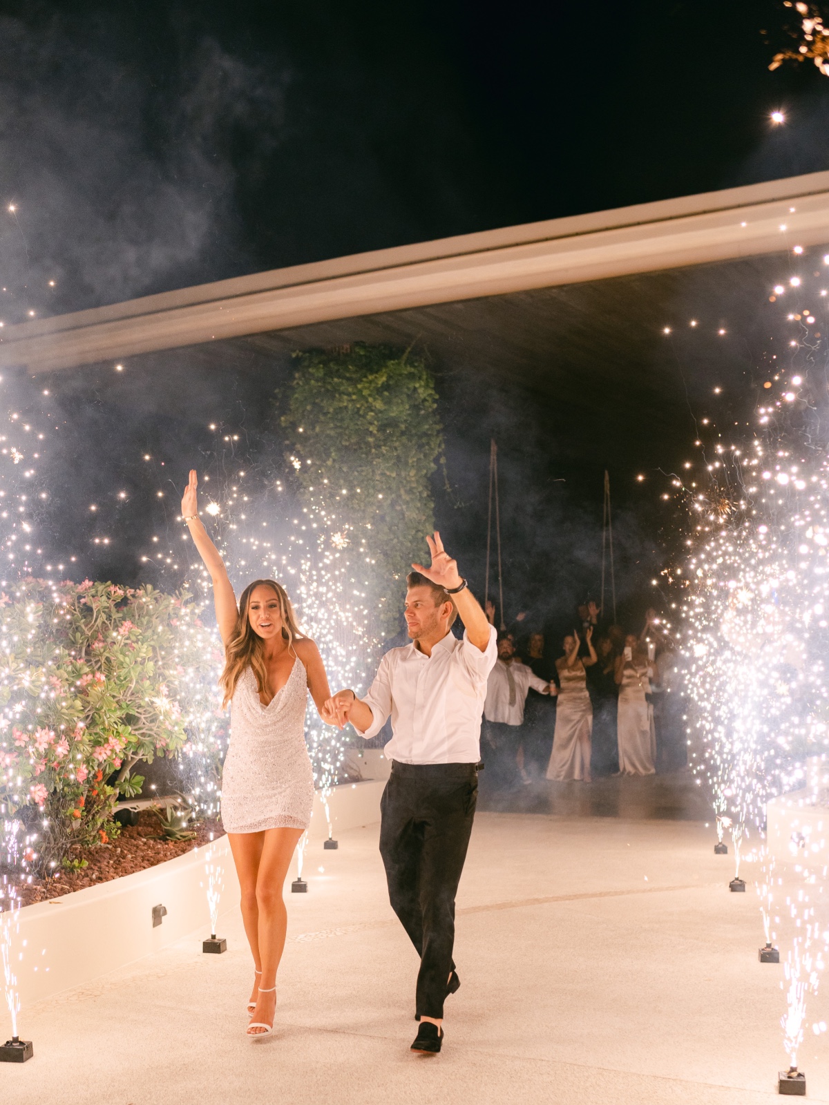 Bride and groom exiting reception to sparkler machine pathway