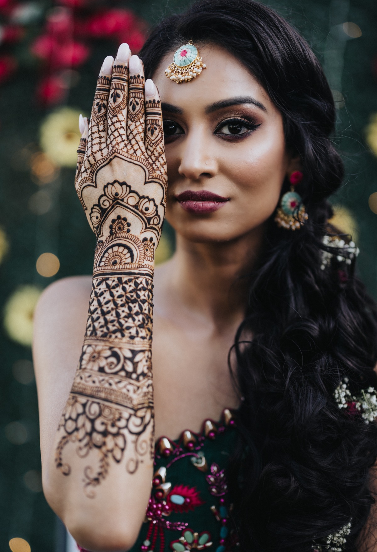Bride holding hand with henna in front of face
