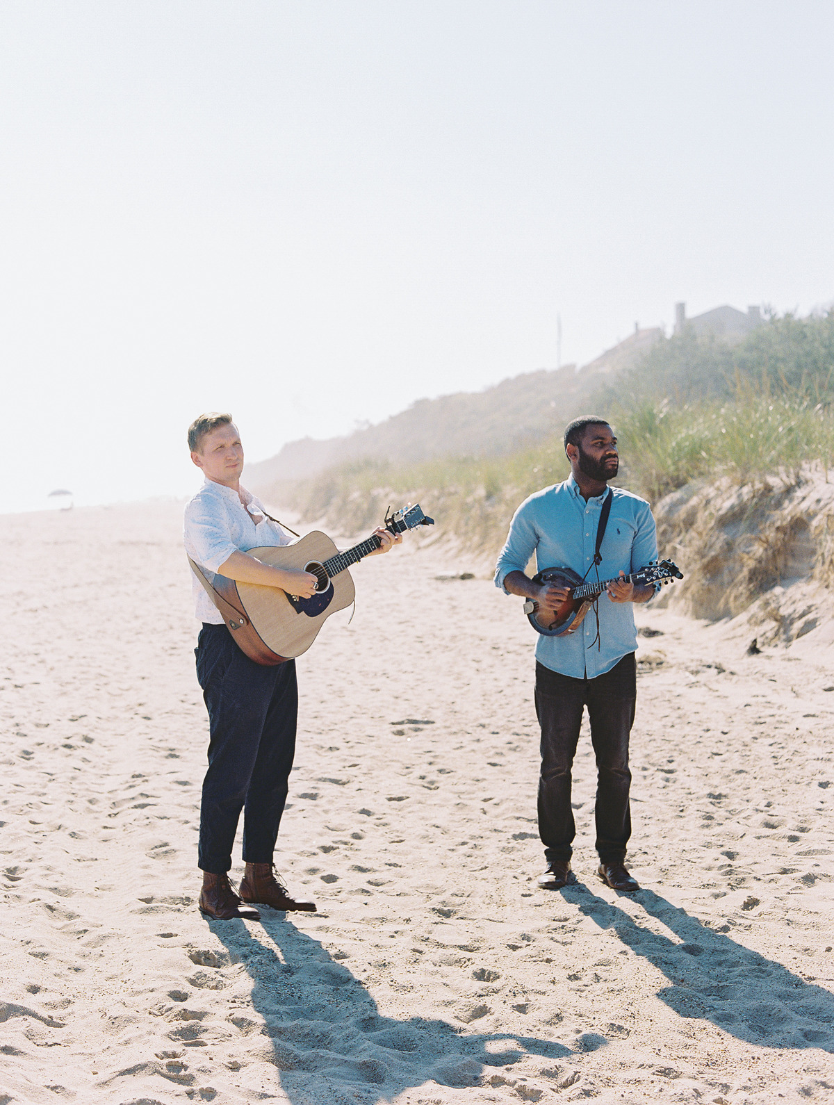Two guitarists playing on beach