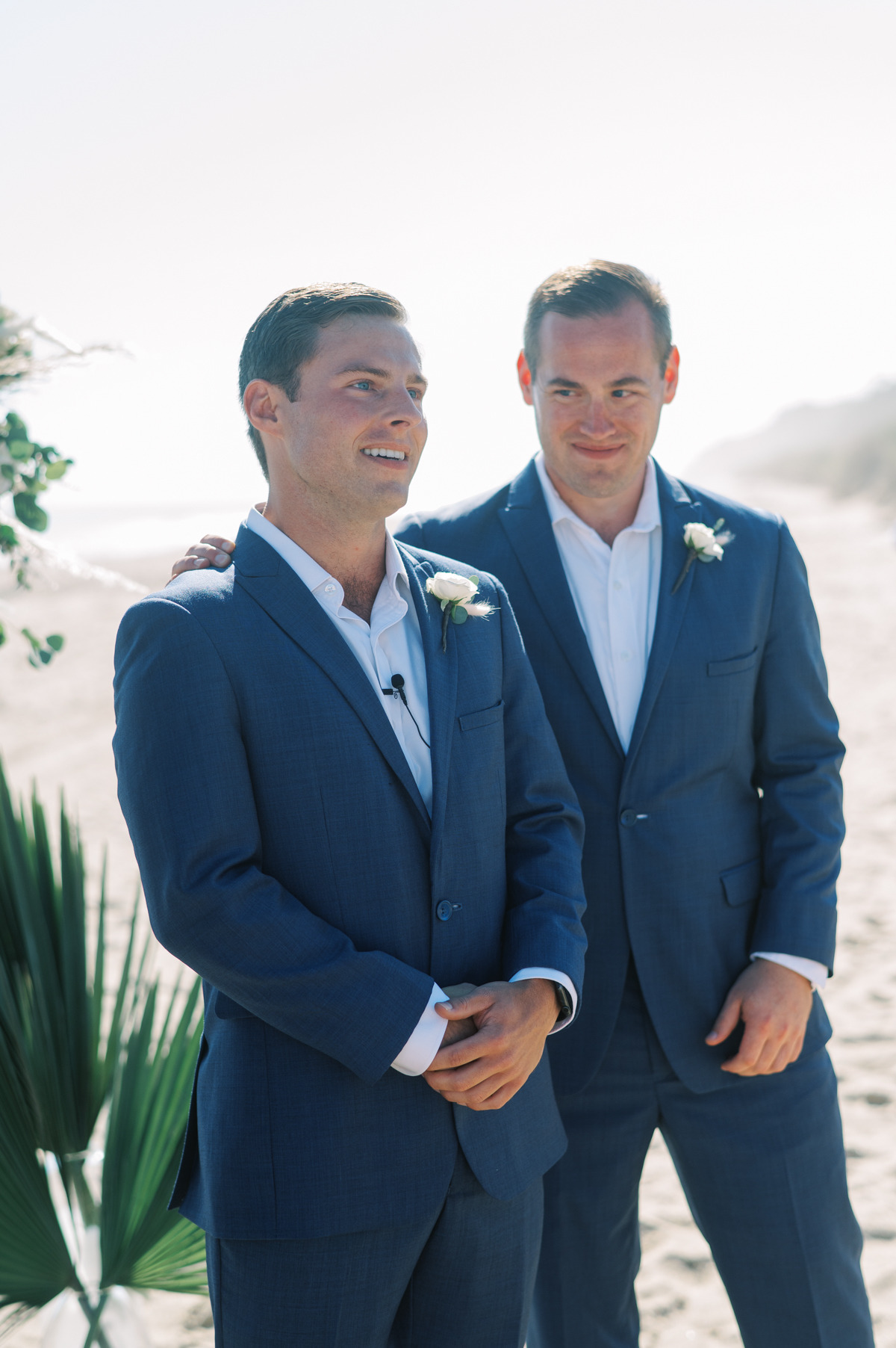 Groom and best man at altar in blue suits