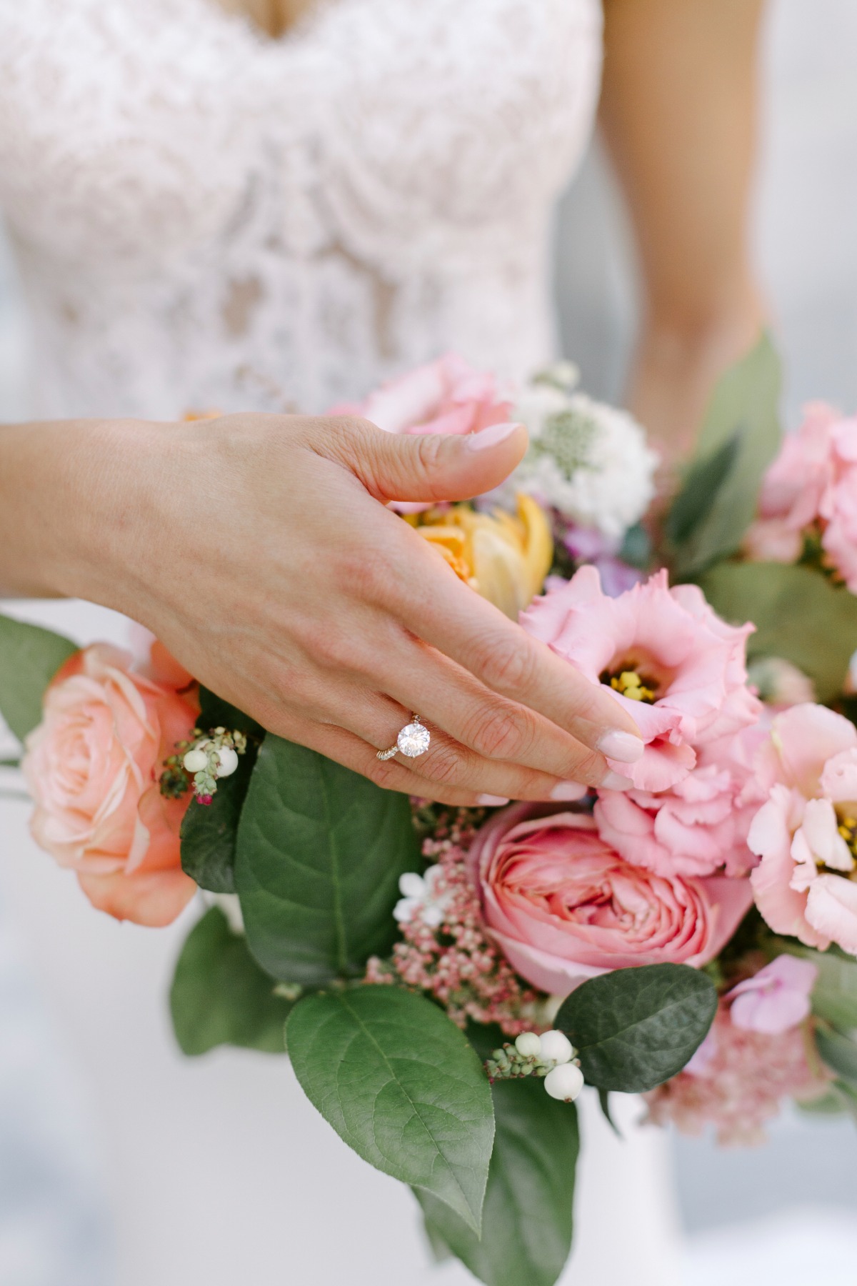 Close-up of engagement ring and bridal bouquet