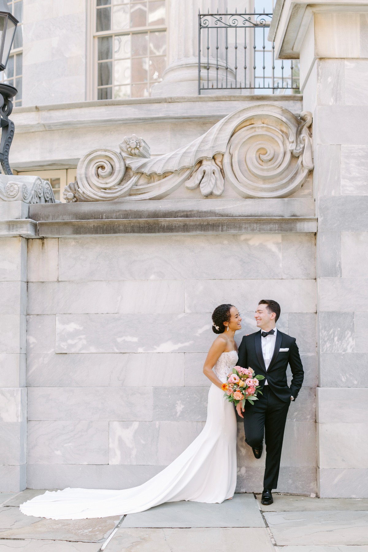 Bride and groom in front of marble wall