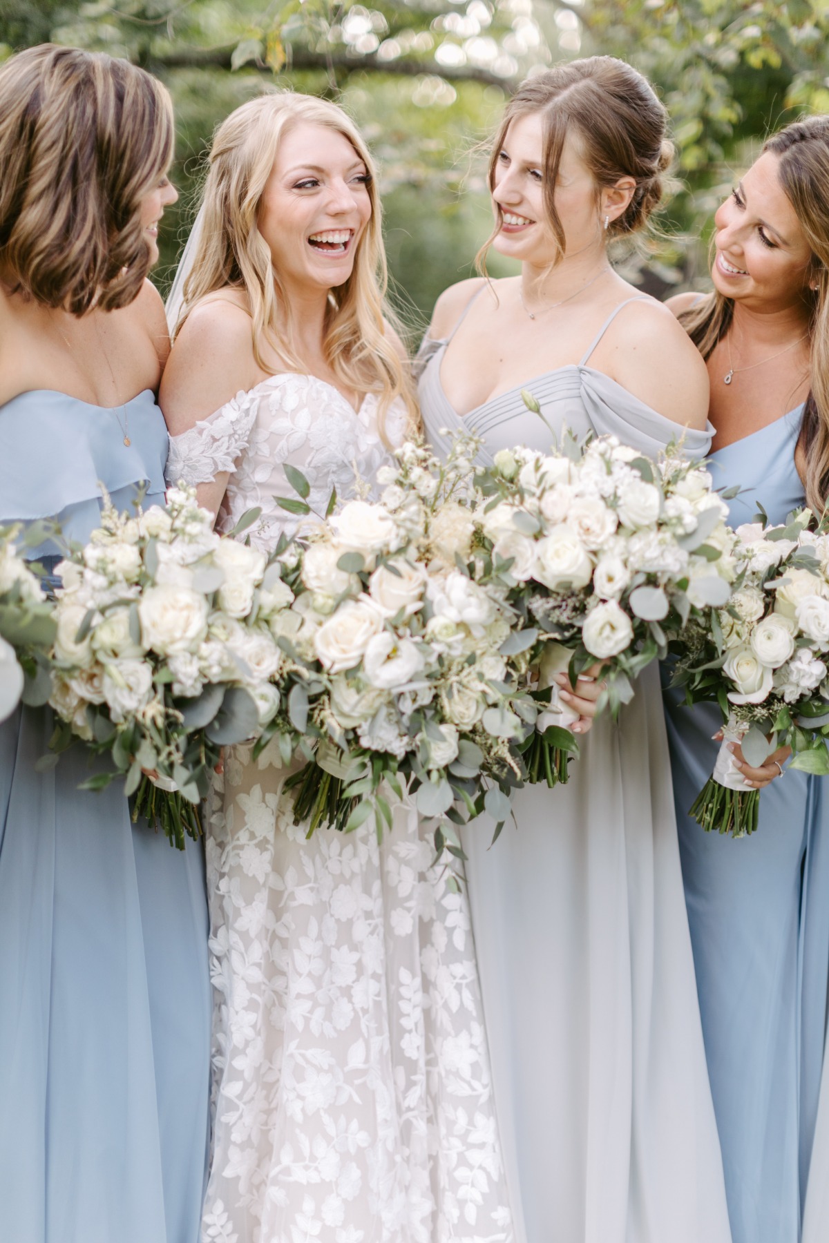 Bride and bridesmaids holding bouquets of white flowers
