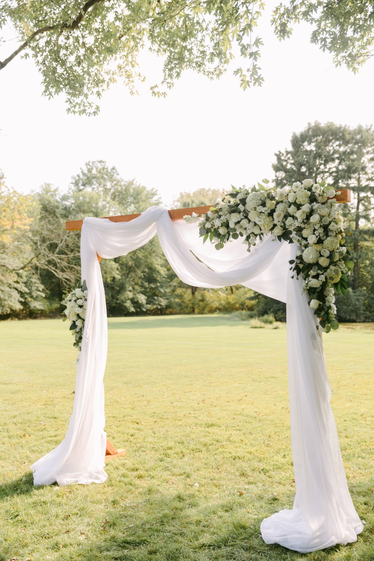 Ceremony altar with white drapery and white floral installation
