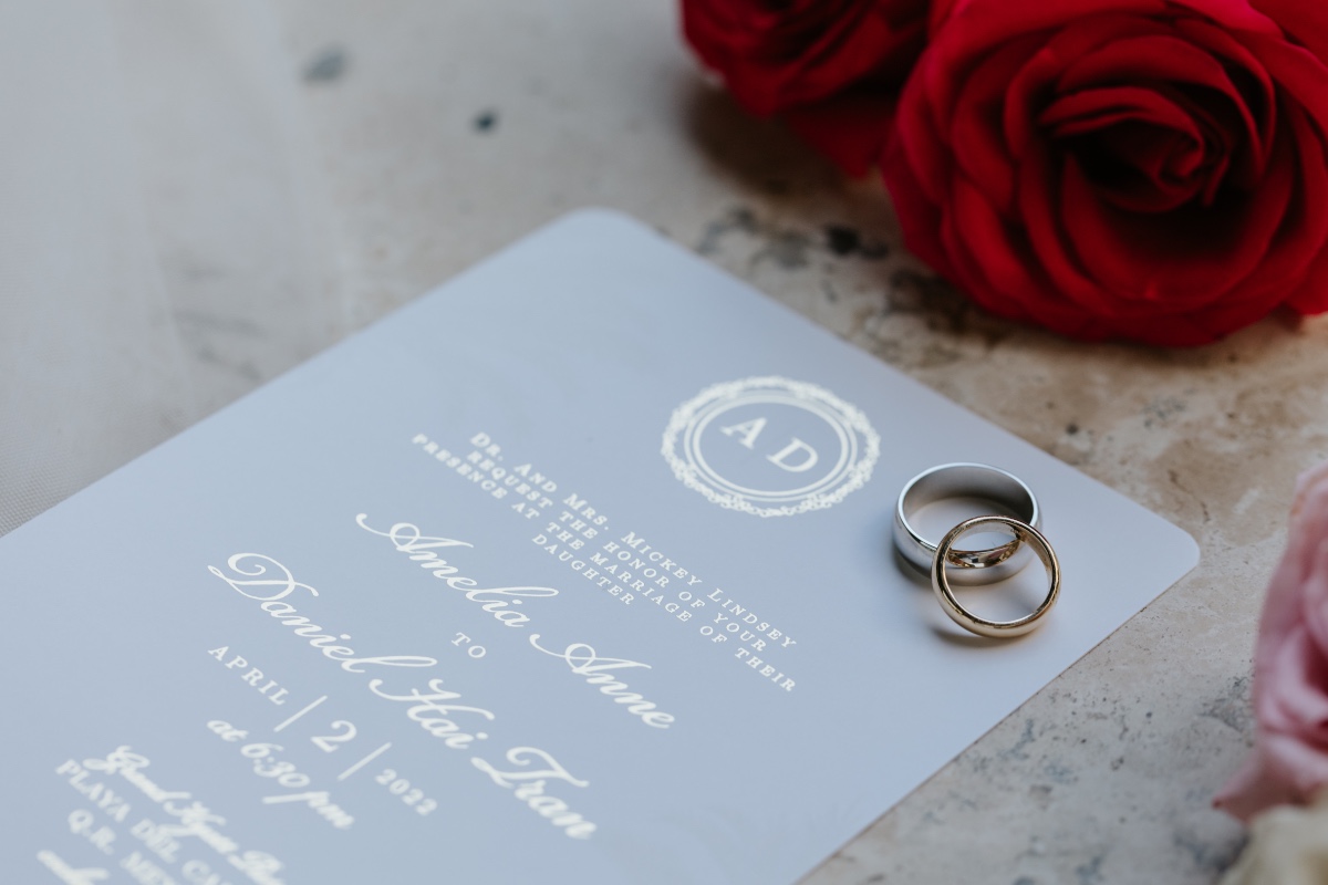 Wedding invitation with wedding rings and one red rose