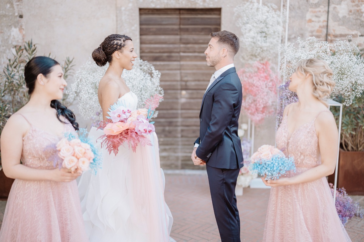Groom, bride, and two bridesmaids at ceremony altar