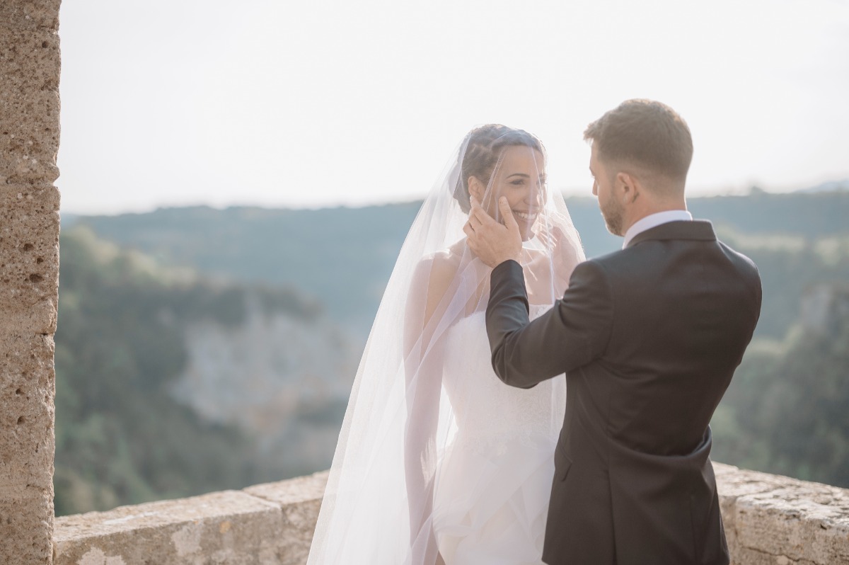 Groom looking at bride with veil