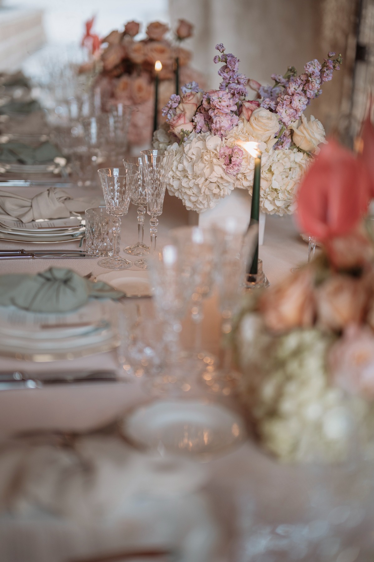 Tablescape with crystal glasses, a candle, and centerpieces