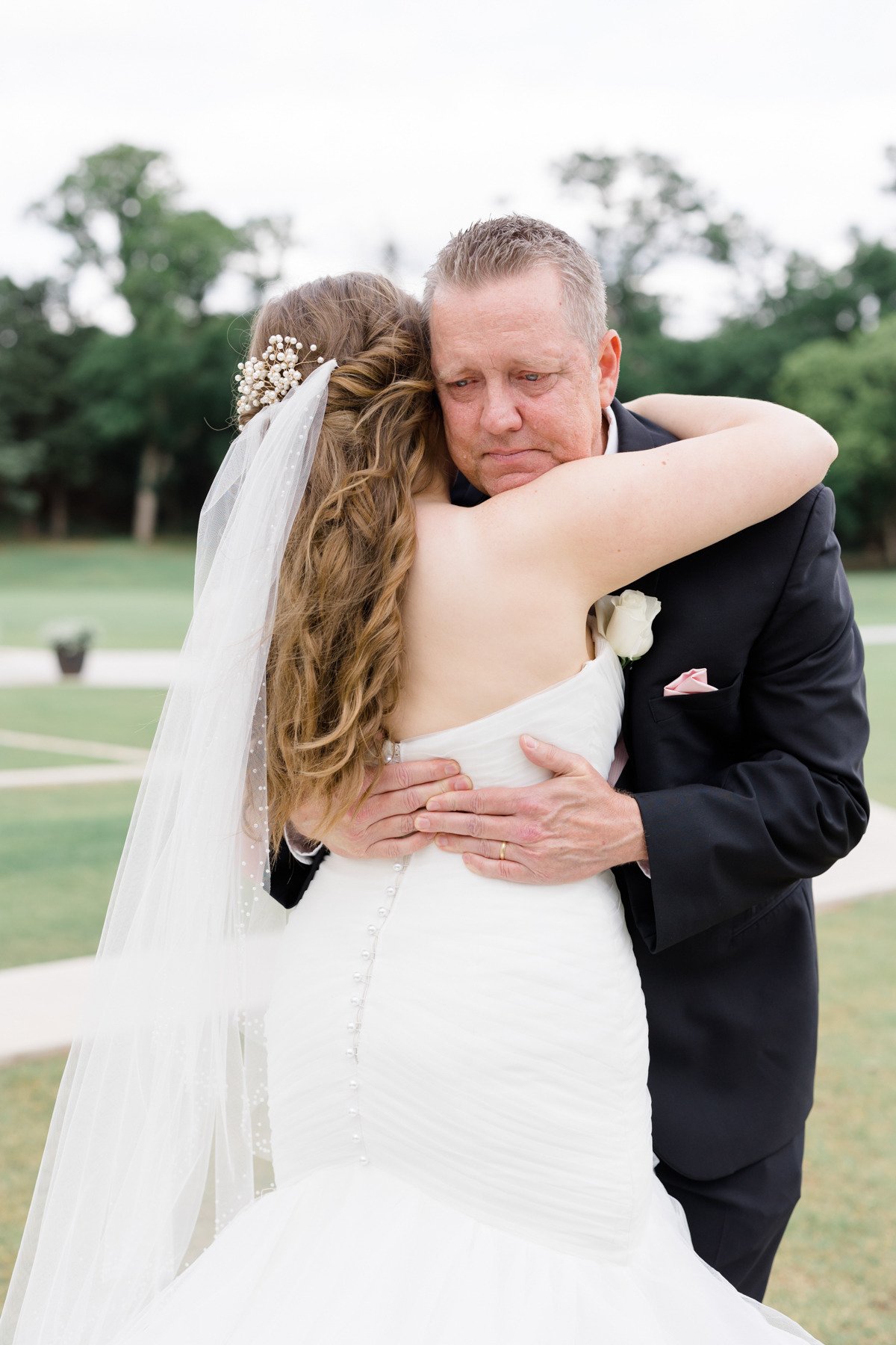bride getting a hug from her father
