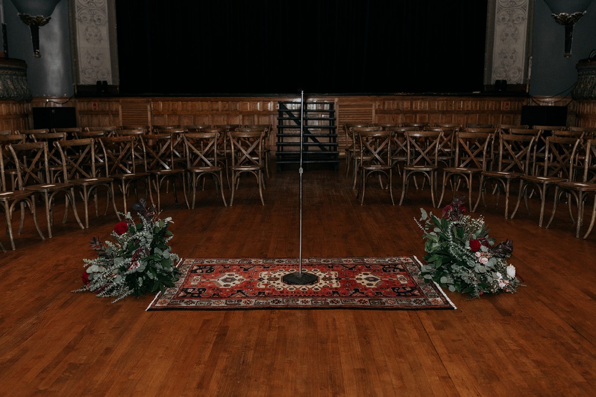 Ceremony altar space on oriental rug with flowers