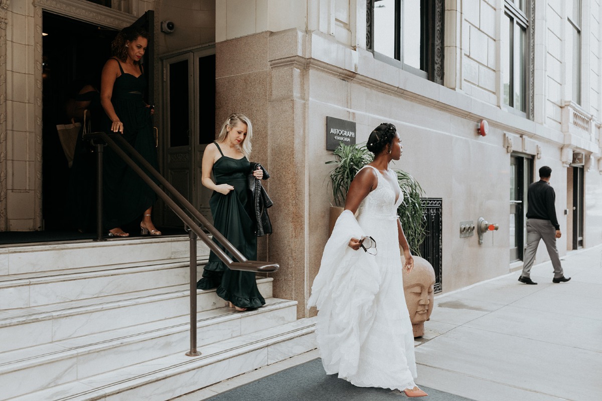 Bride walking out of hotel with two bridesmaids