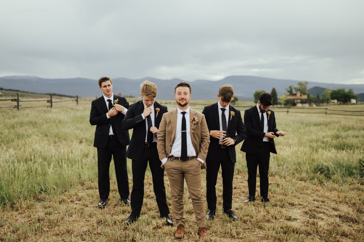 Groomsmen in black suits with yellow florals