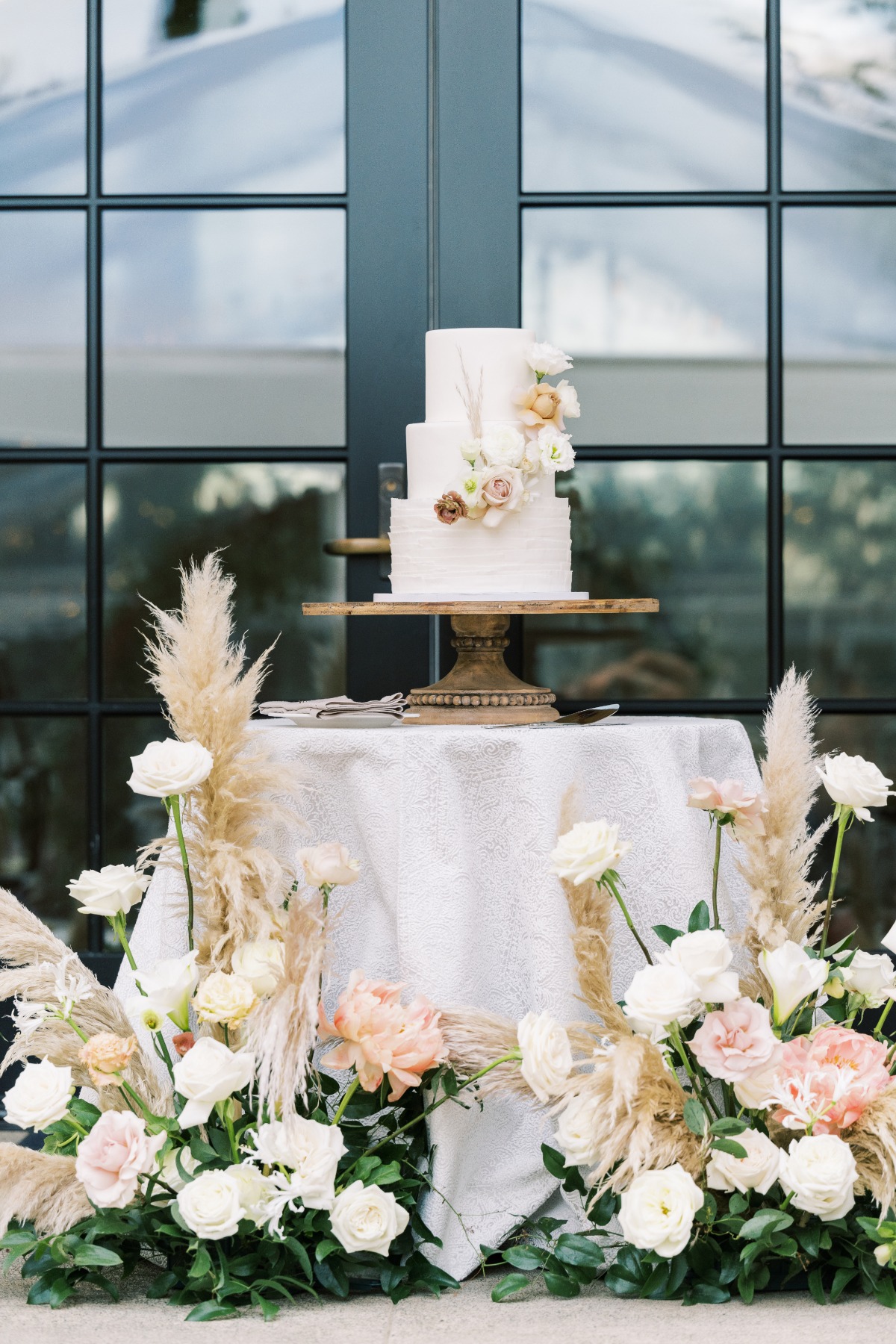 Wedding cake on table surrounded by florals