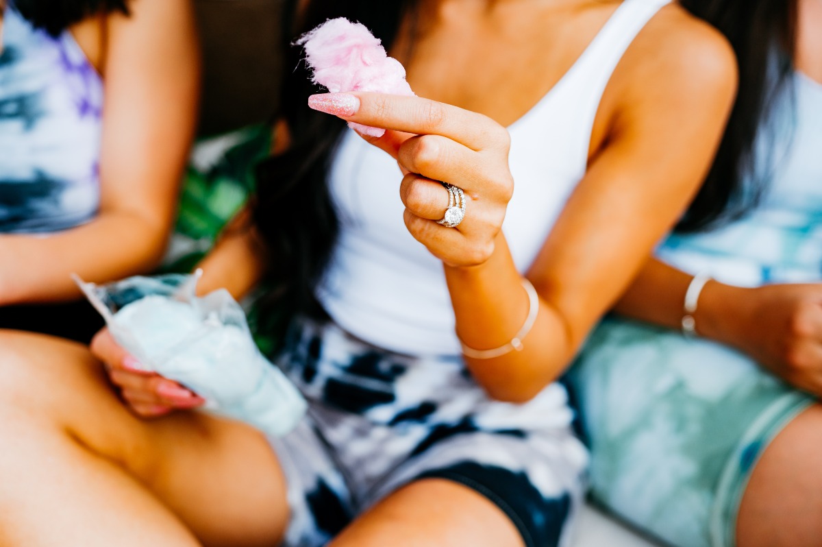 One bachelorette eating cotton candy wearing engagement ring