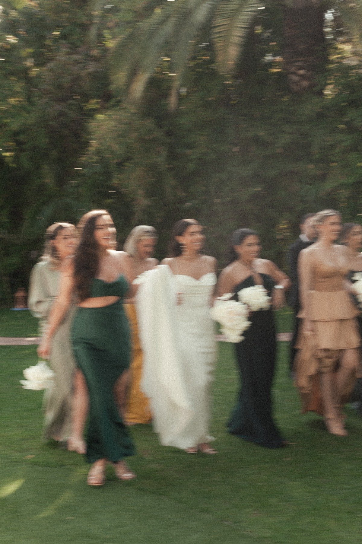 Bride and bridesmaids walking on grass