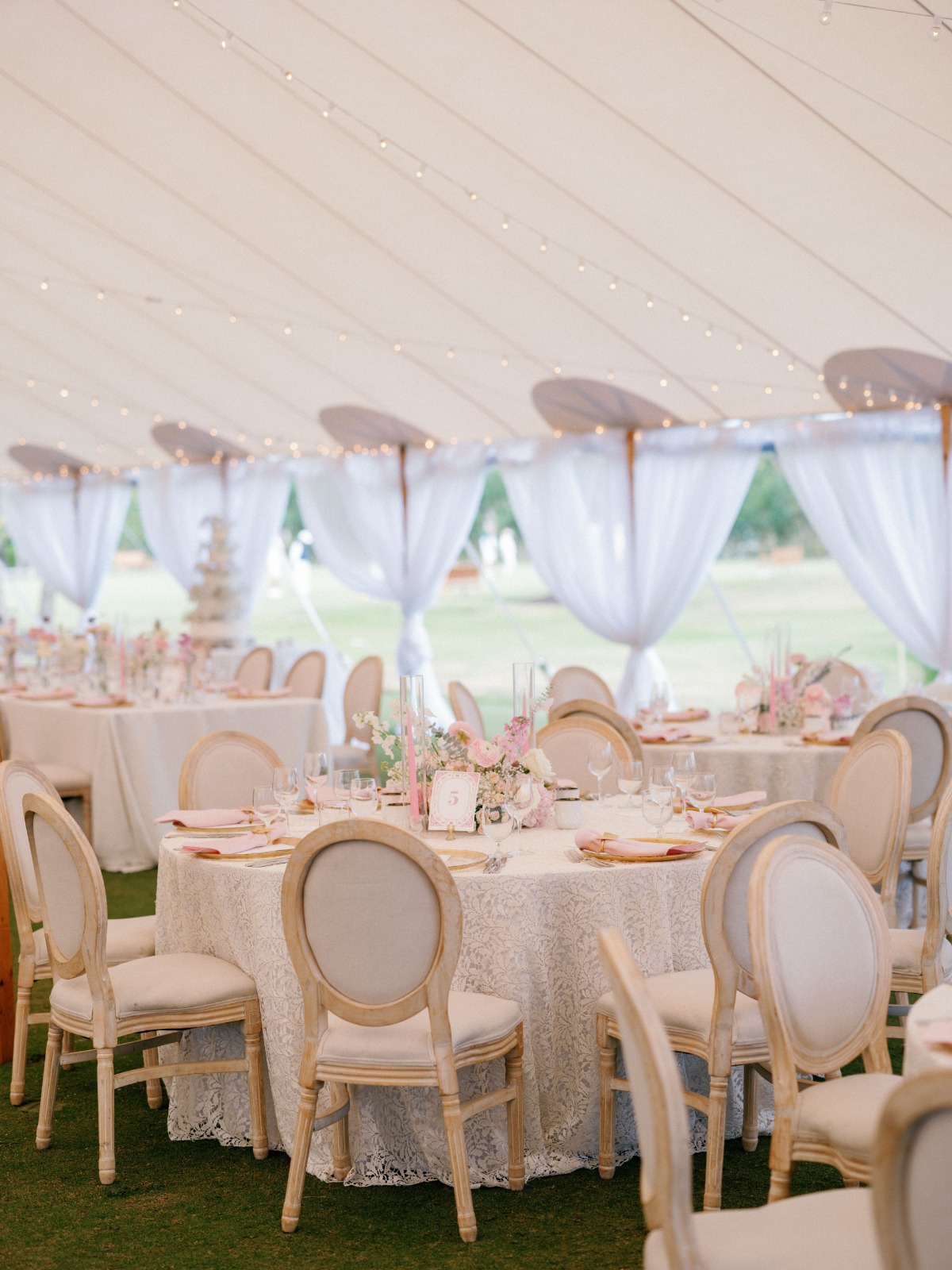 Floor to ceiling photo of reception tent including table and centerpiece