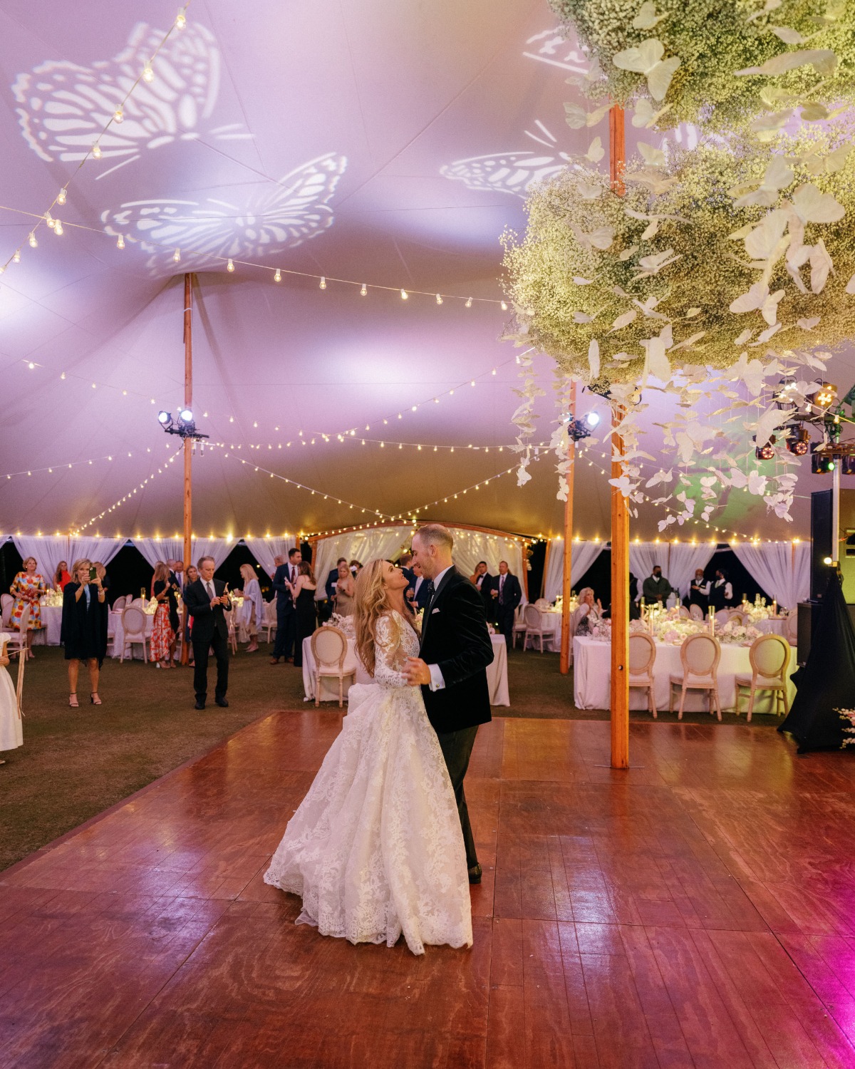 Bride and groom first dance under baby's breath clouds and butterflies