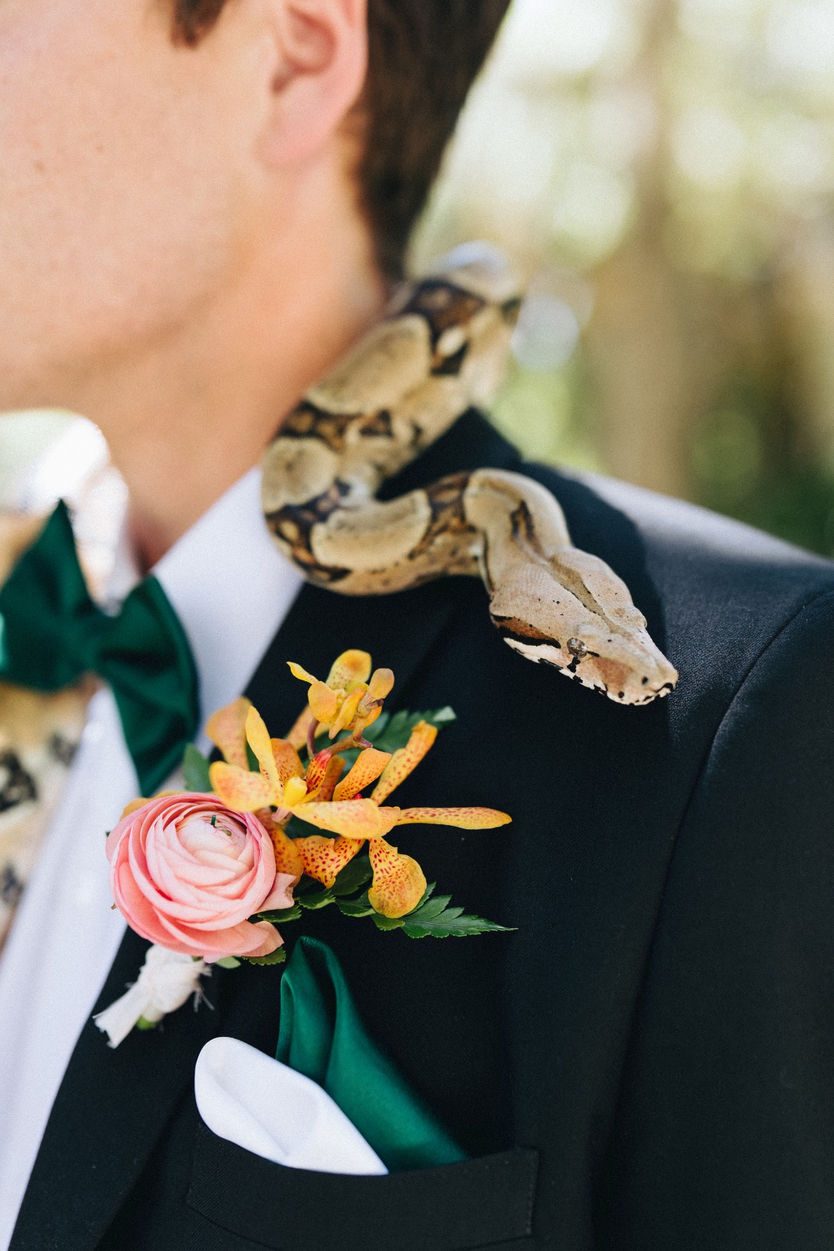 Groom with boutonniere and snake around his neck