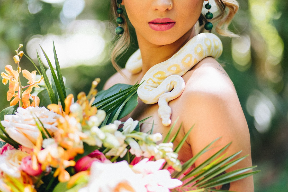 Bride holding bouquet with snake around her neck