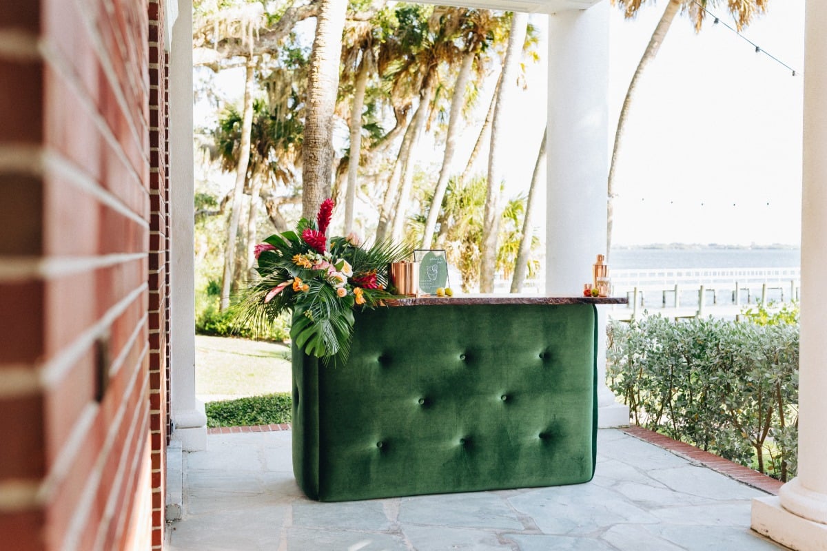 Green velvet bar set-up with tropical flower arrangement