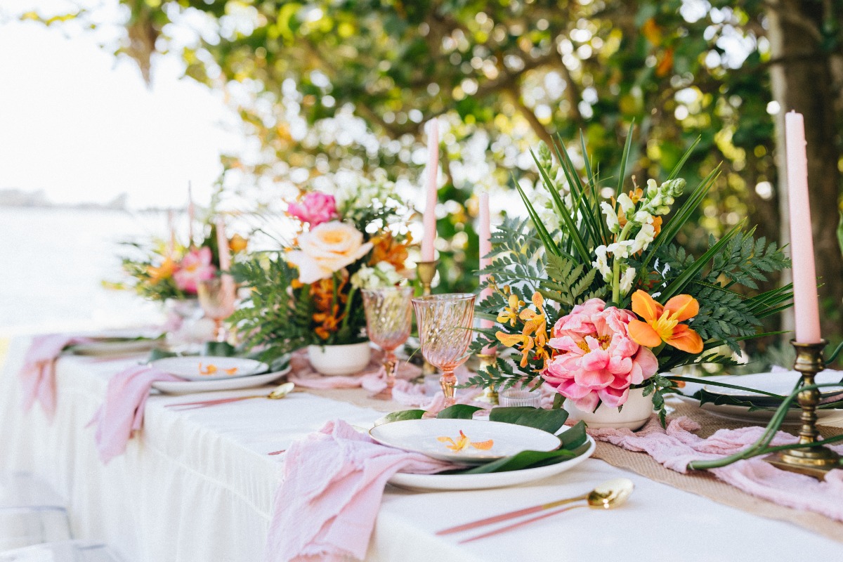 Reception table with tropical florals and colorful glassware