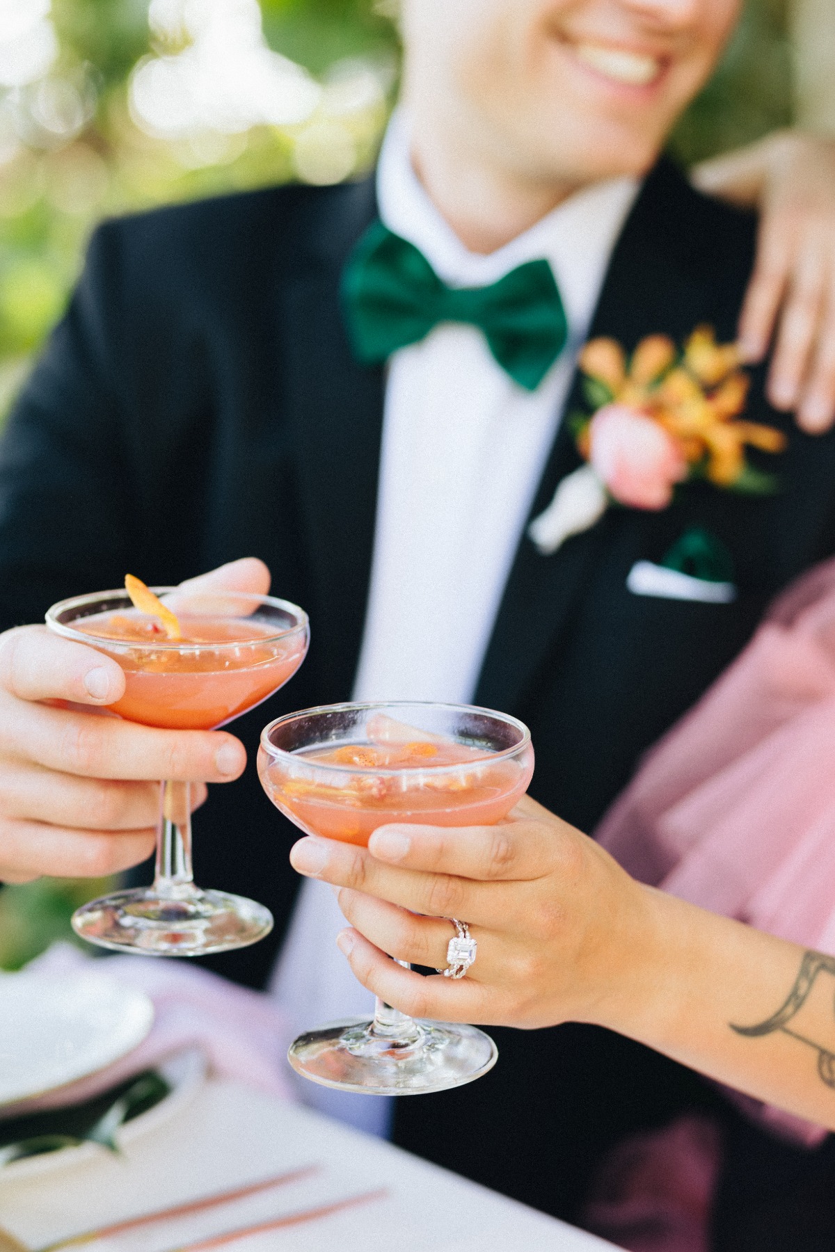 Bride and groom say cheers with two cocktails