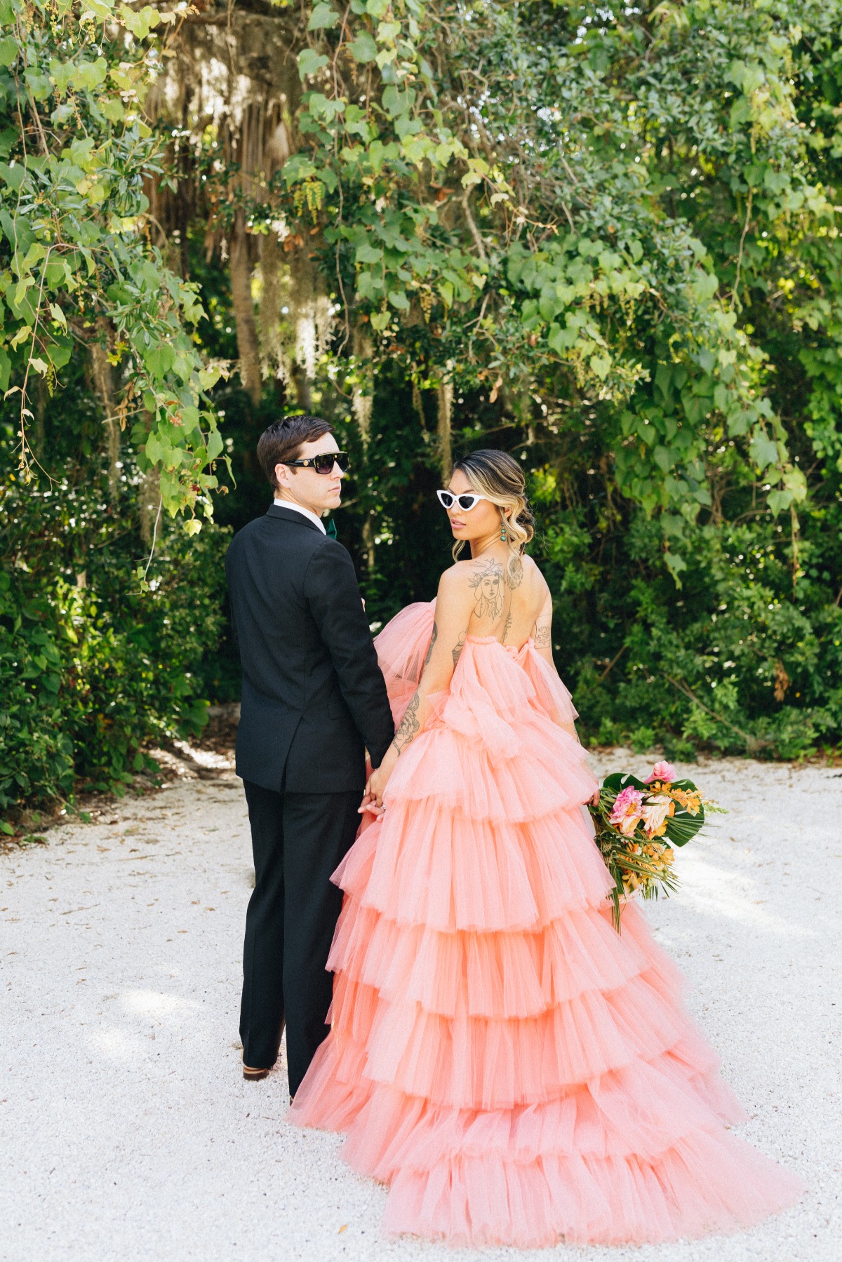 Bride and Groom looking back toward camera in sunglasses