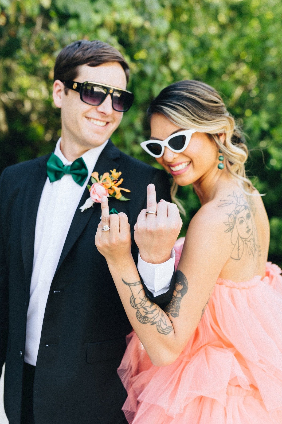 Bride and groom wearing sunglasses and showing wedding rings