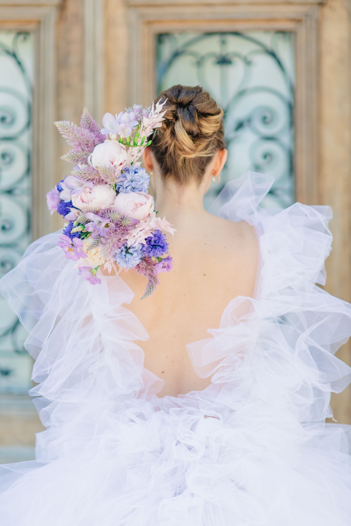 View of bride's updo with bouquet