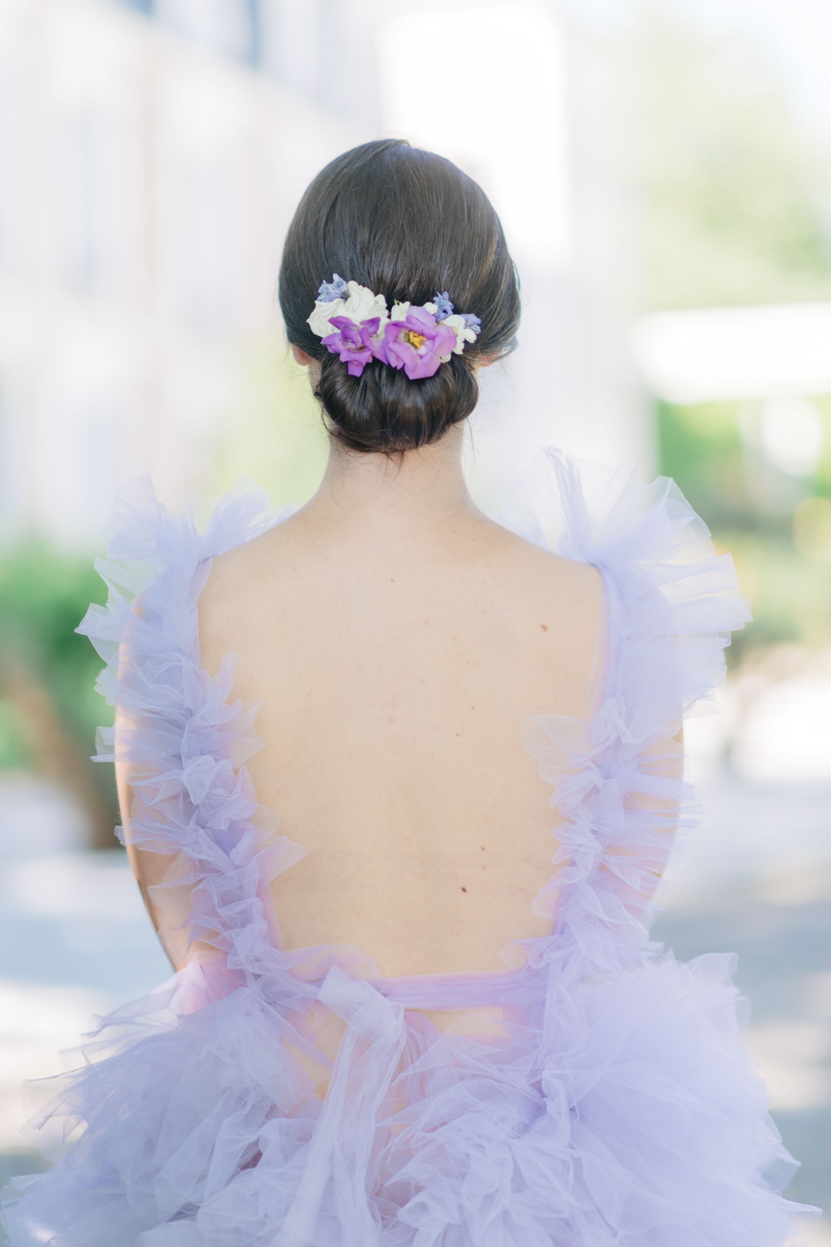 View of bridesmaid updo with floral hair piece