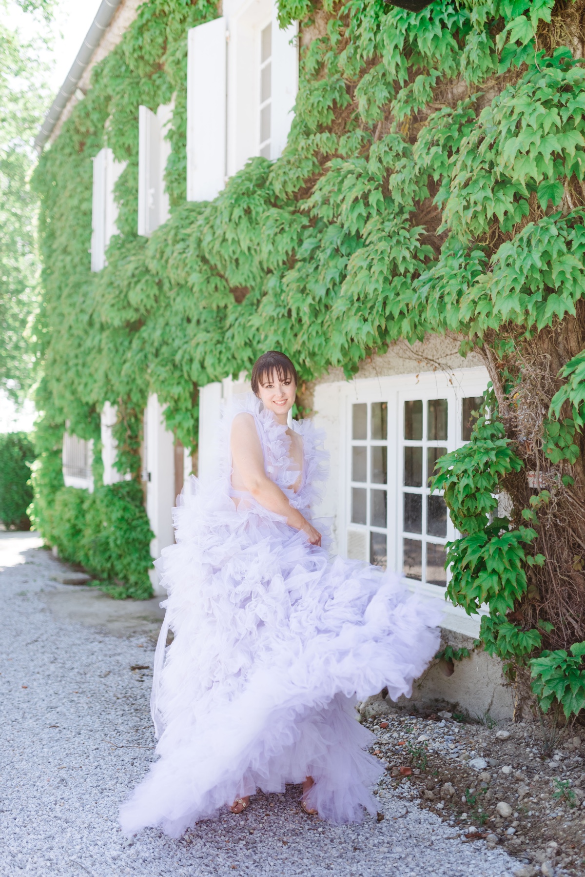 Portrait of bridesmaid in lilac tulle in front of ivy wall
