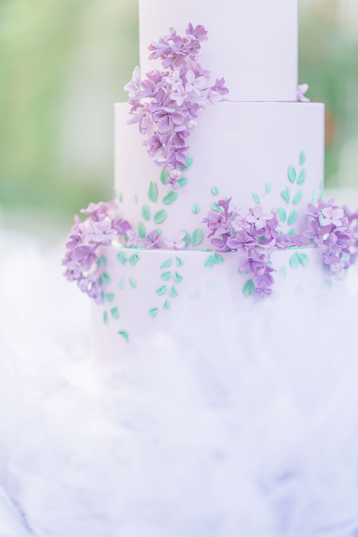 Close-up of wedding cake with lilacs