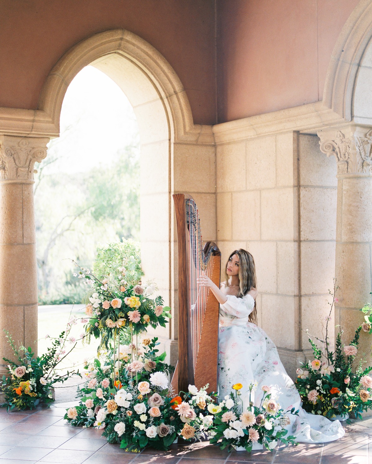 Bride playing a harp among flowers
