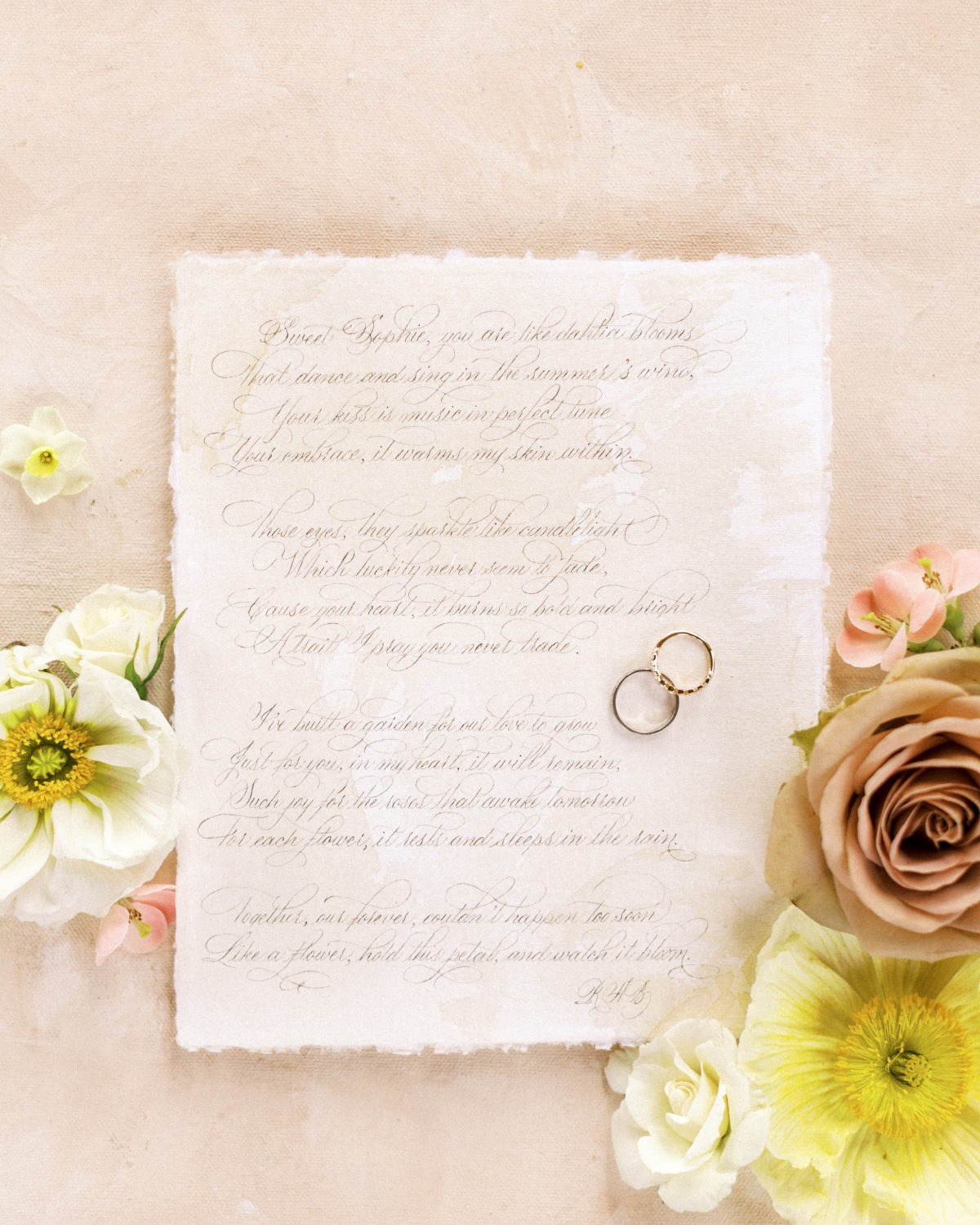 Aerial view of vows with wedding bands and flowers