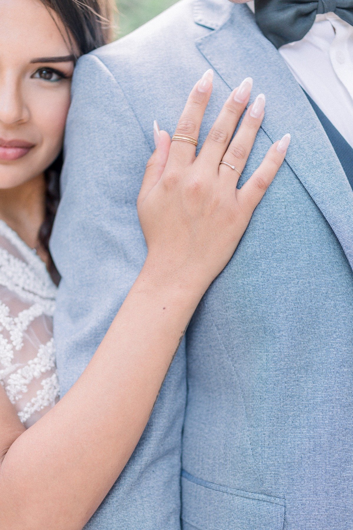 Close-up of bride's hand on groom's shoulder