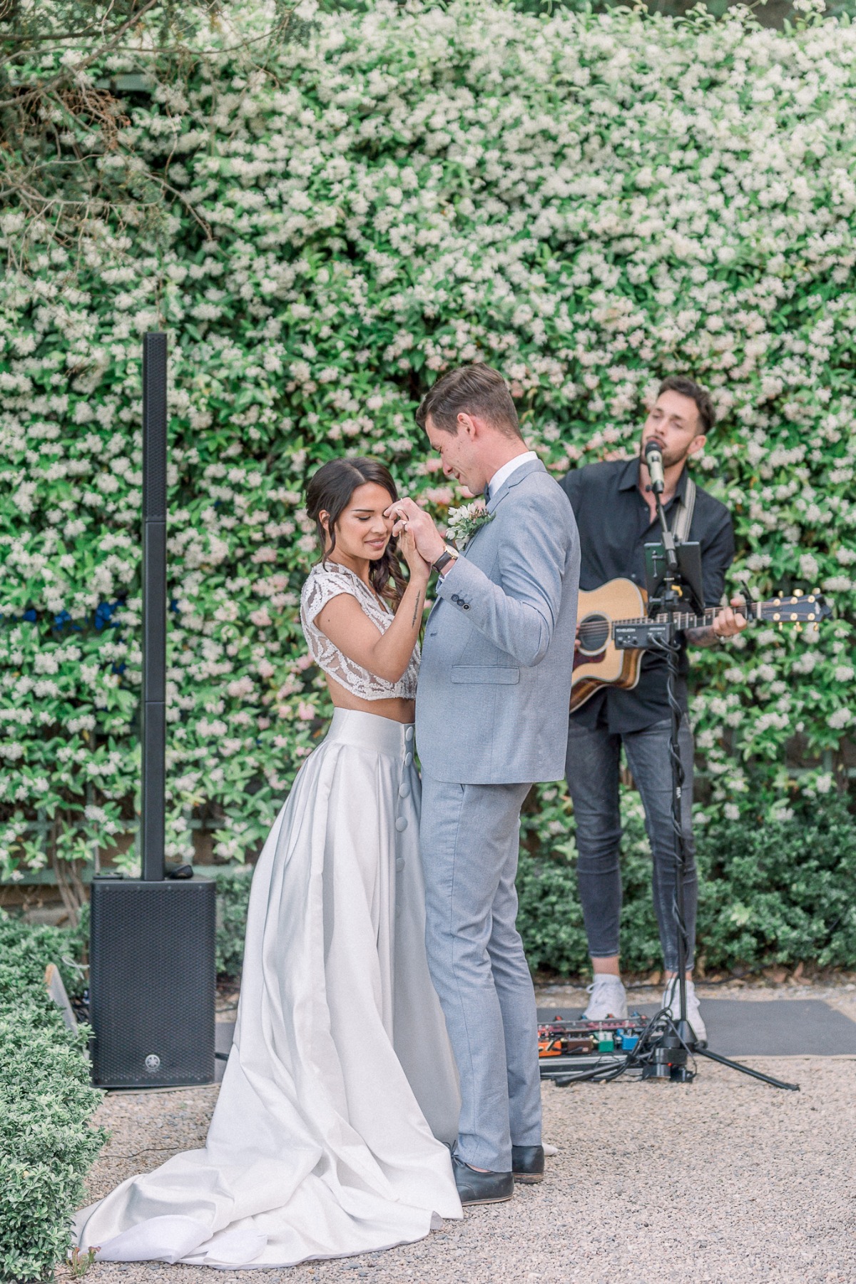 Bride and groom dancing in front of guitar player