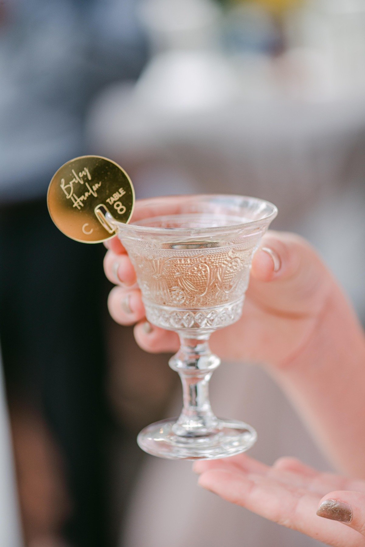 Vintage champagne glass held in air with personalized rim ornament