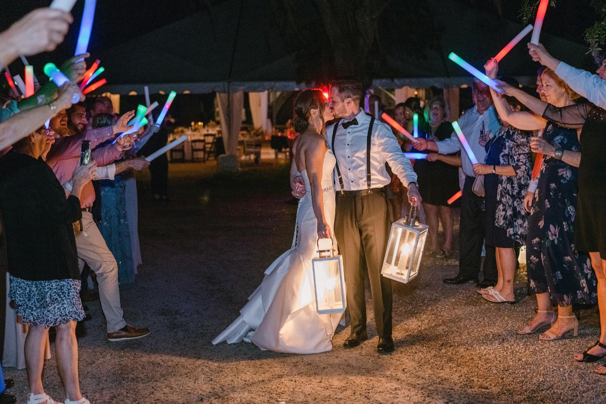 Bride and groom exiting reception with a glow stick exit holding lanterns
