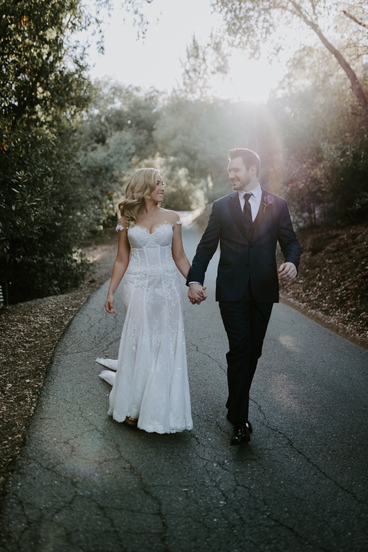 Bride and groom holding hands for portrait on road