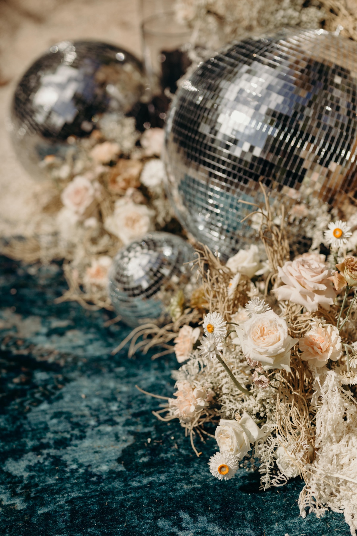Ceremony florals, disco ball, and blue carpet