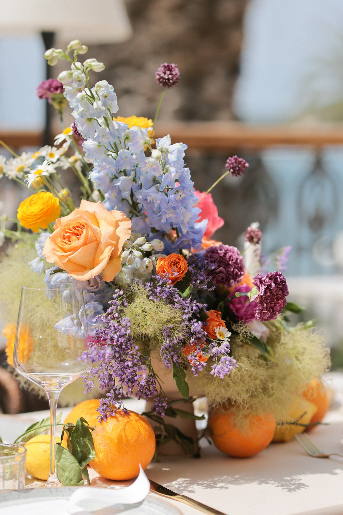 Close up of colorful floral arrangement with oranges and lemon underneath