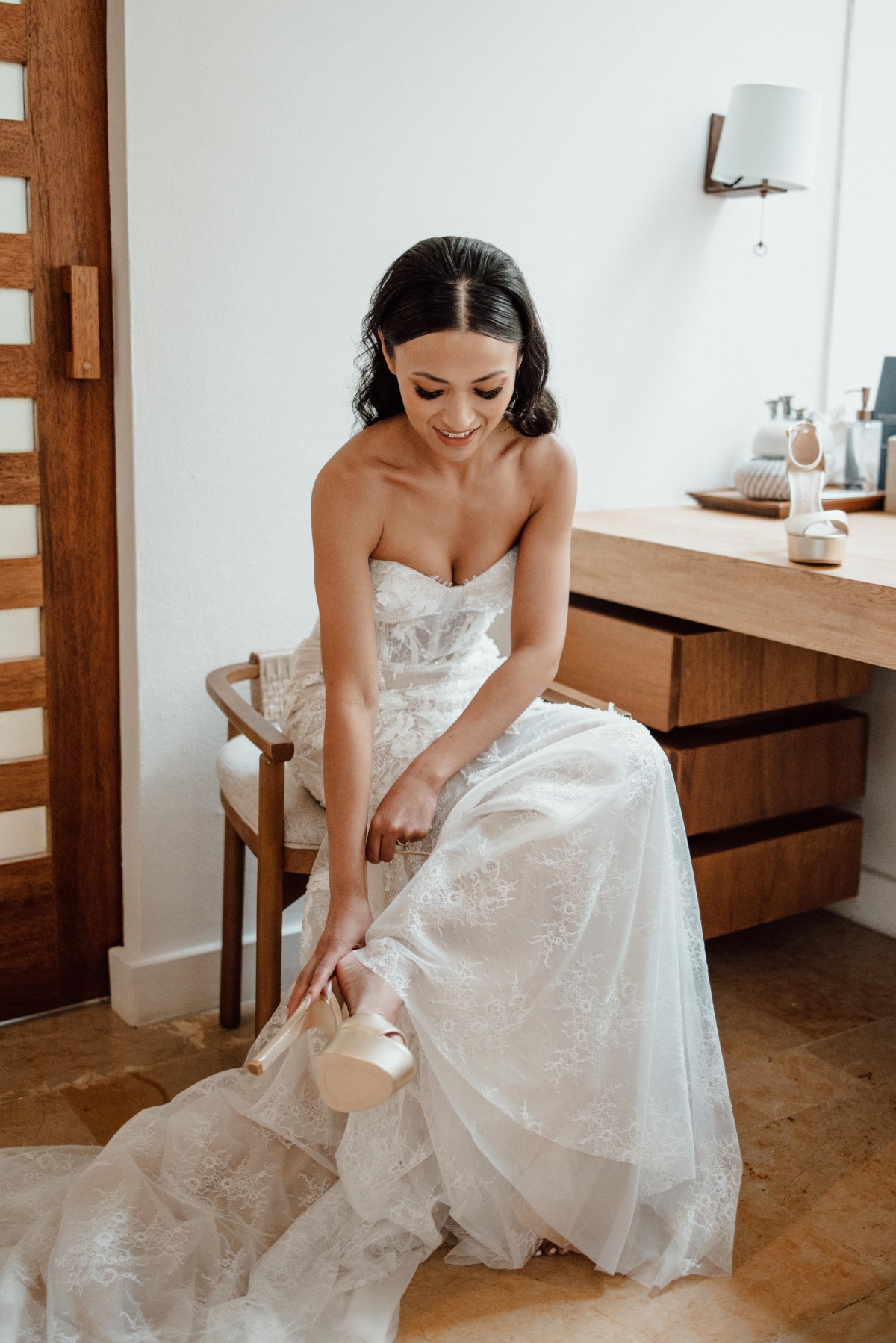 Bride seated buckling champagne colored wedding shoe