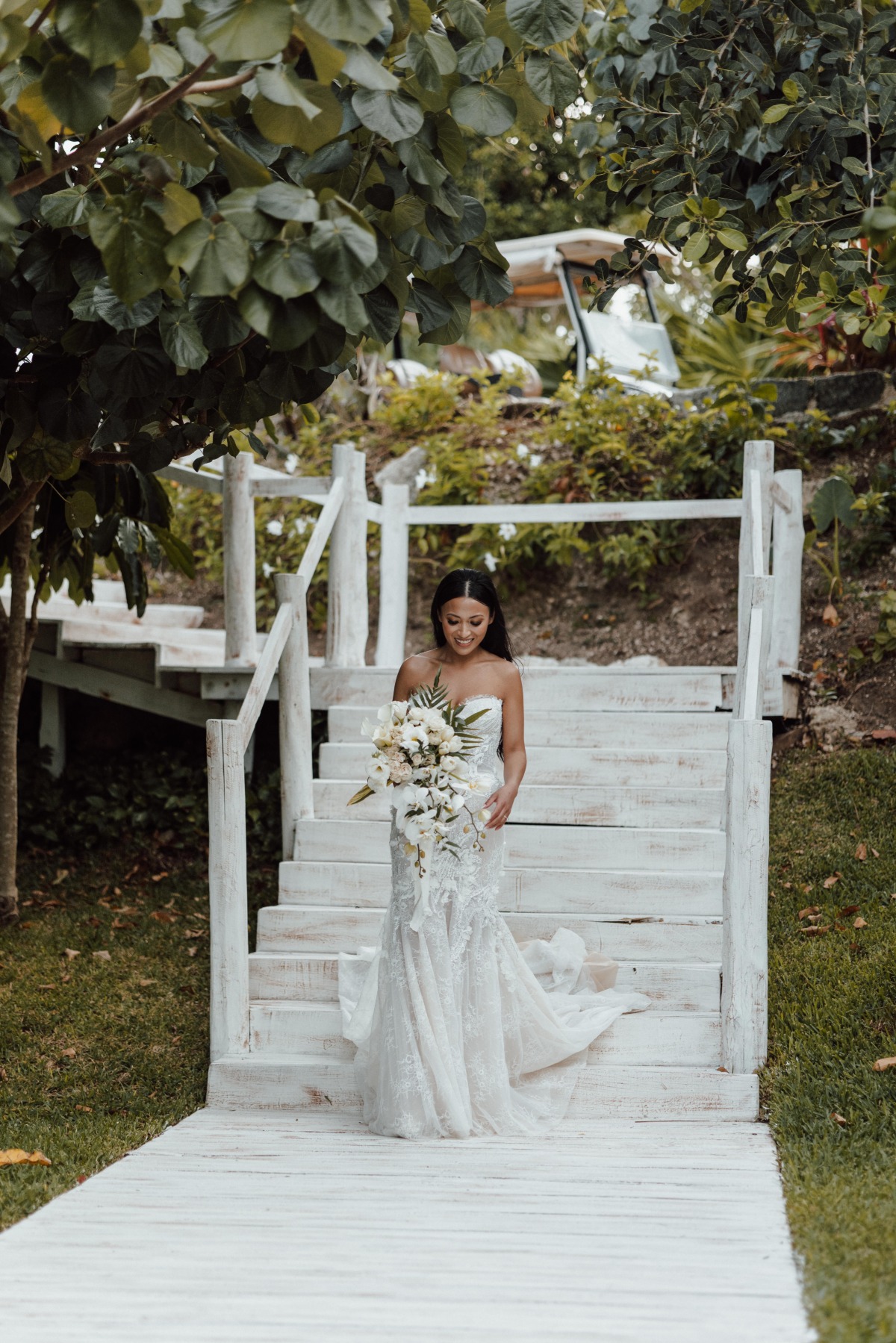 Bride walking down white steps to ceremony