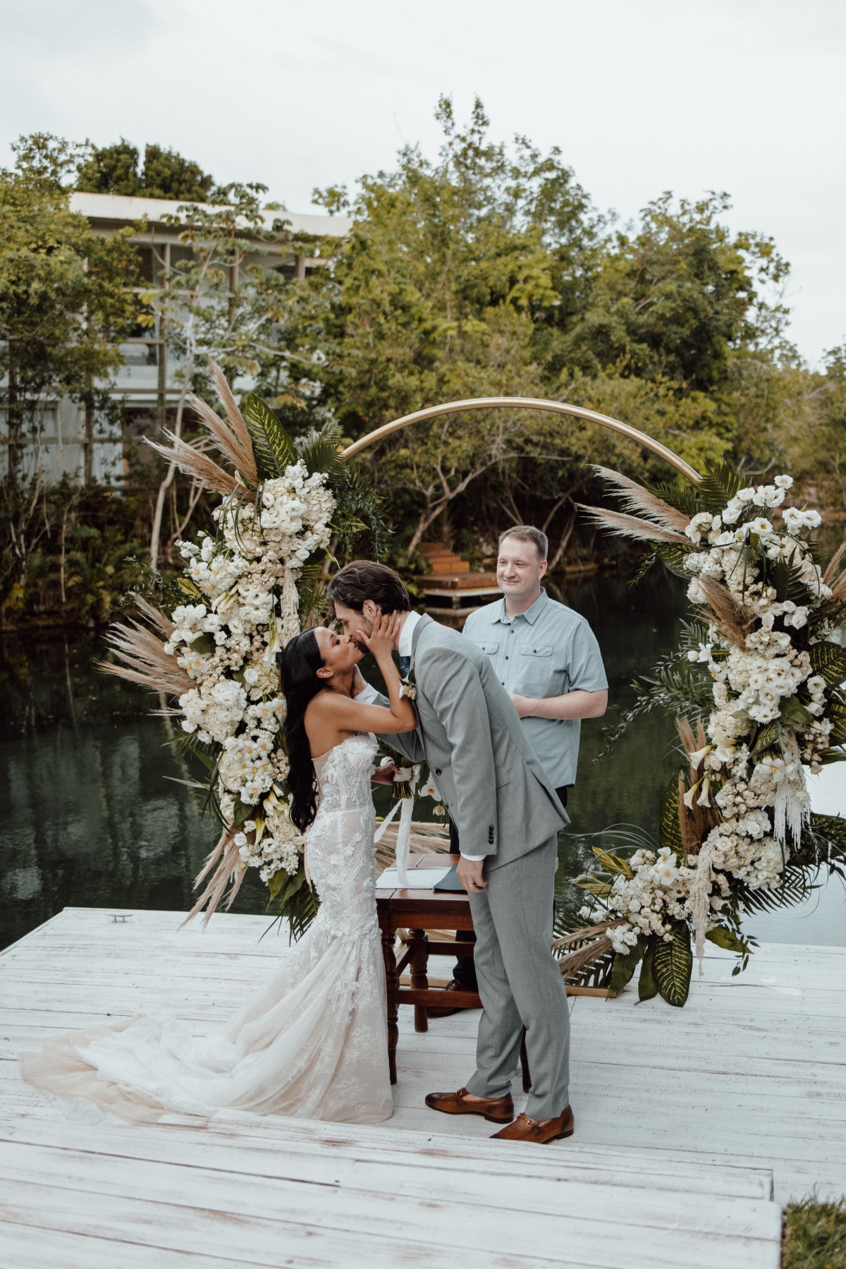 Bride and groom kissing at end of ceremony in front of altar installation