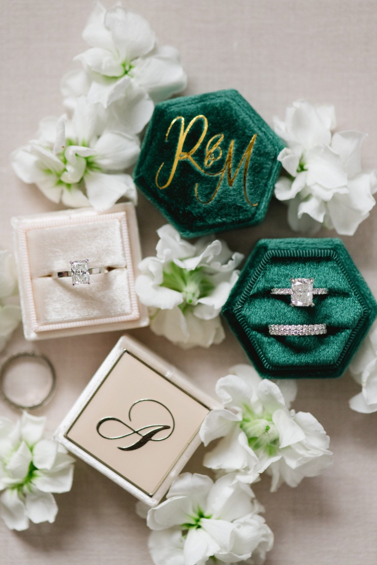 Aerial view of monogrammed ring boxes with engagement and wedding rings