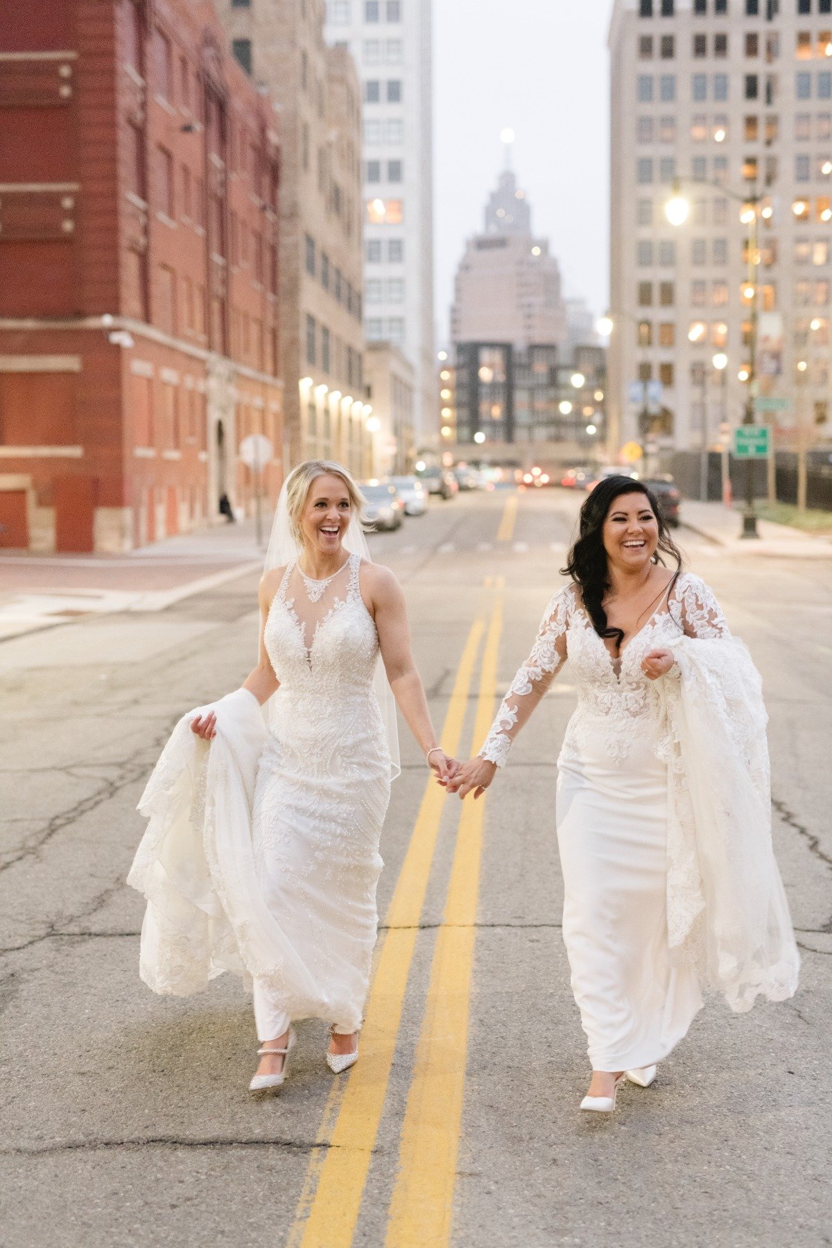 Brides holding hands walking down Detroit street